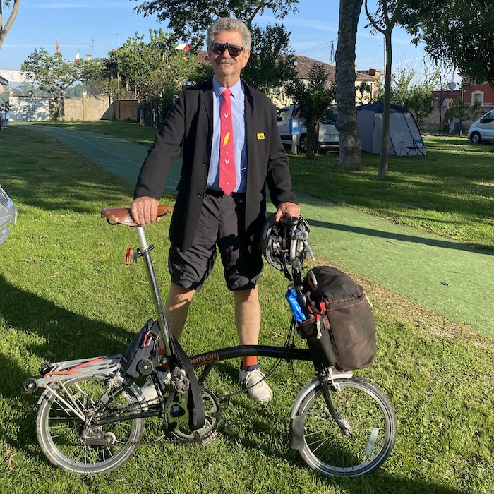 Me, wearing black jacket, blue shirt, pink tie and shorts, proudly ready to ride my antique Brompton to the Championships